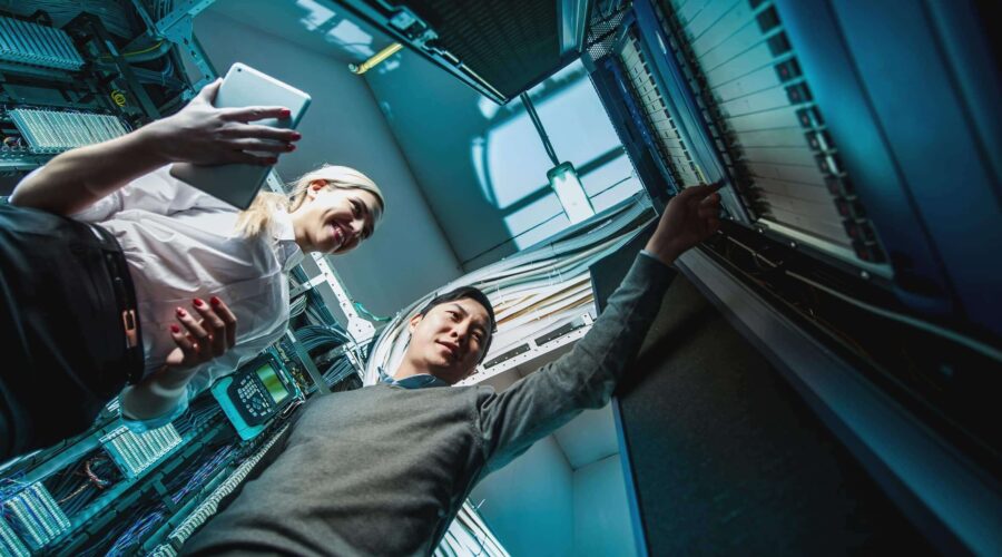 Two IT professionals working in a server room-what does it support