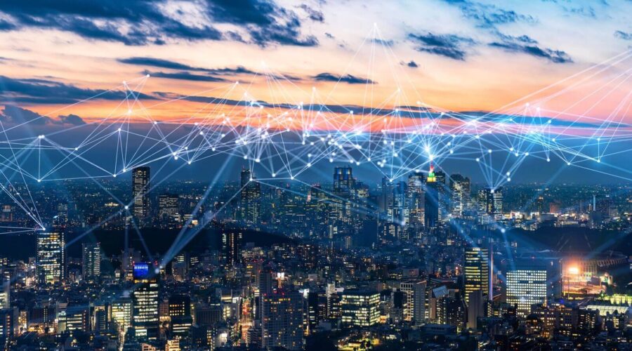 A futuristic city skyline at dusk with a digital network overlay-internet of things​