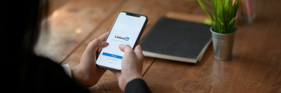 Person using linkedin using mobile phon - how to leverage social media for business growth