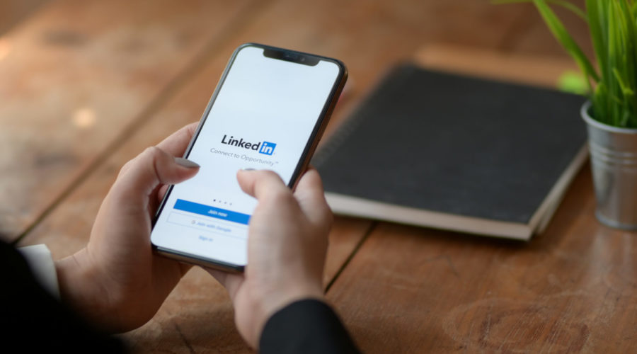 Person using linkedin using mobile phon - how to leverage social media for business growth