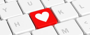 Close-up of a computer keyboard with a red key featuring a white heart symbol-computer cleaning solution