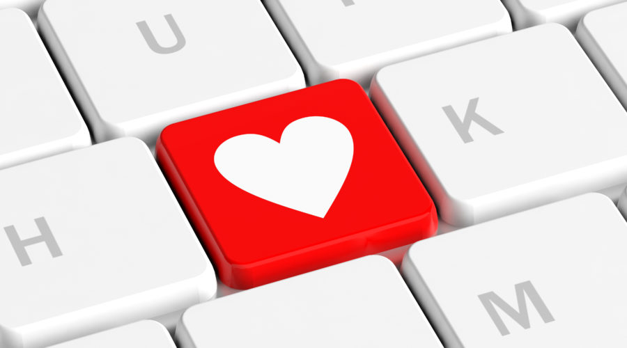 Close-up of a computer keyboard with a red key featuring a white heart symbol-computer cleaning solution
