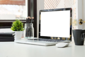 Minimalist workspace with a laptop, books, and a coffee cup on a white desk-device cleanup
