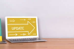 A laptop on a wooden desk displaying an Update-software update