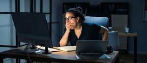 woman sitting at a desk with shocked expression- colonial pipeline cyber attack