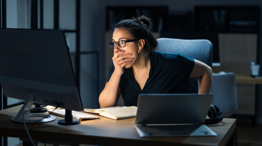 woman sitting at a desk with shocked expression- colonial pipeline cyber attack